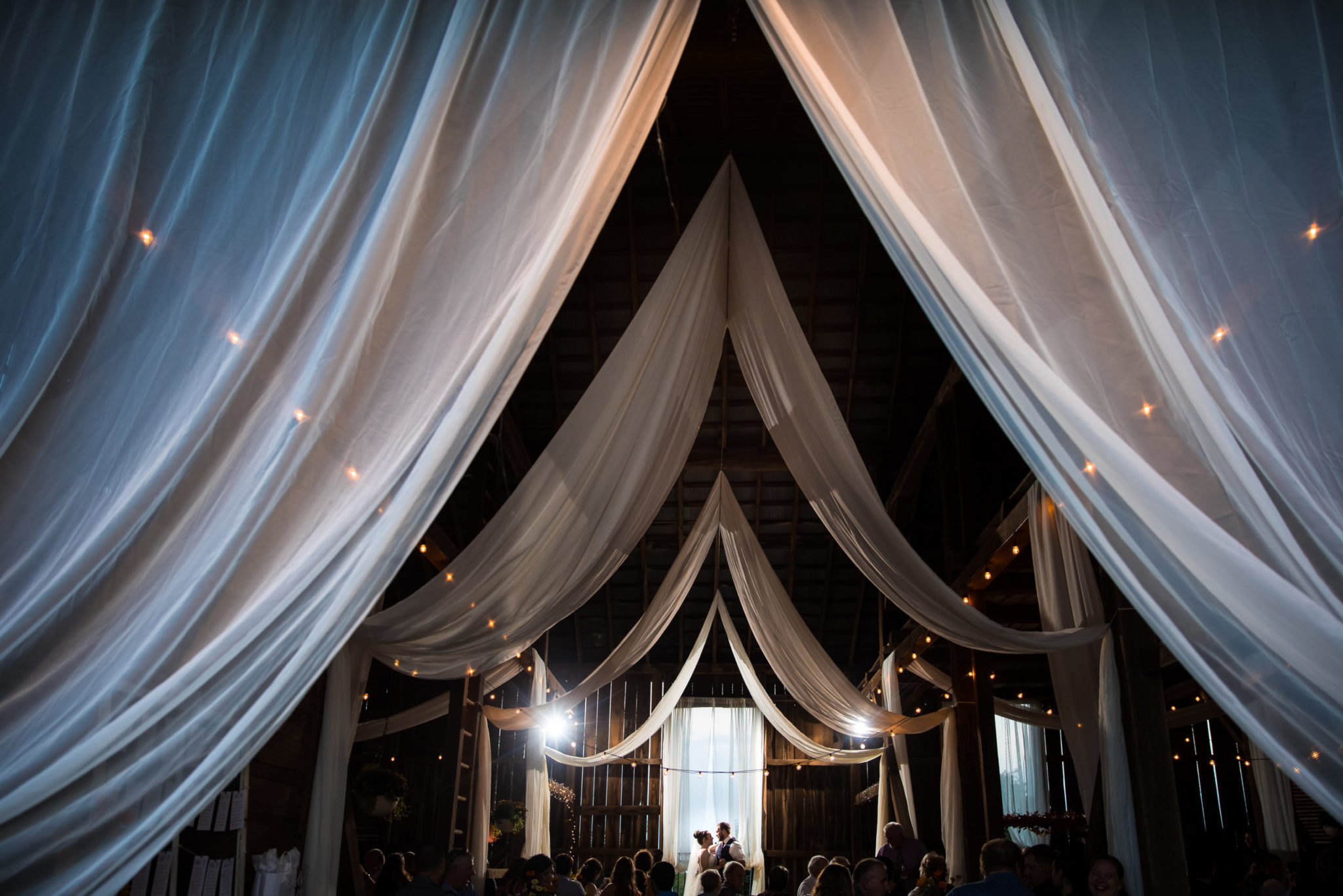 Central PA Wedding Photographer, Lisa Rhinehart, captures this image of the bride and groom as they share their first dance underneath the curtains draped down 