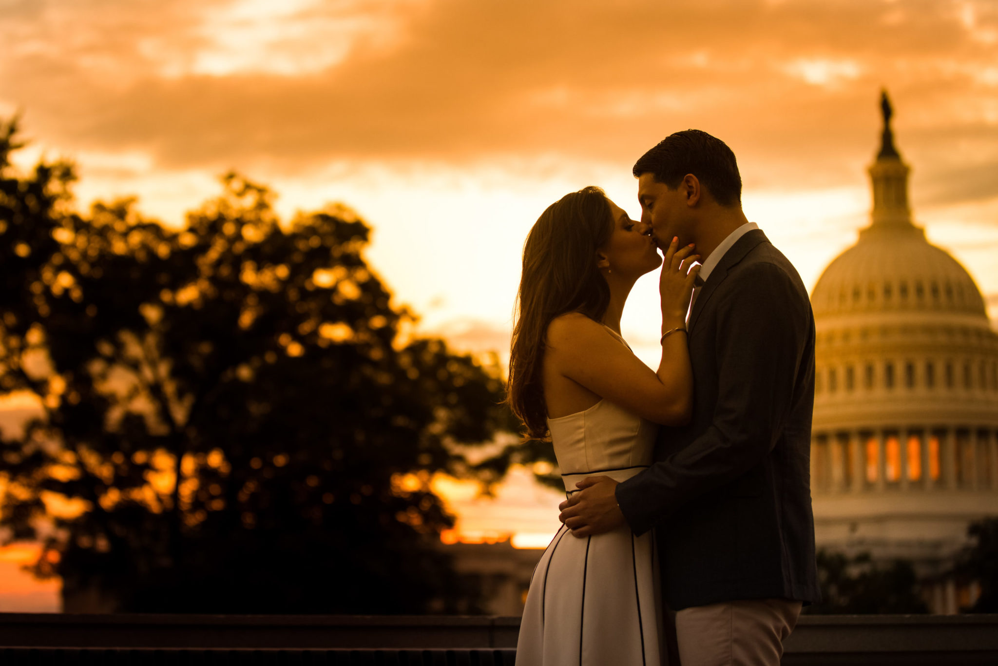 Washington DC Wedding Photographer, Lisa Rhinehart, captures this golden hour image of the bride and groom kissing as the sun sets behind them with DC monuments in the background behind them 