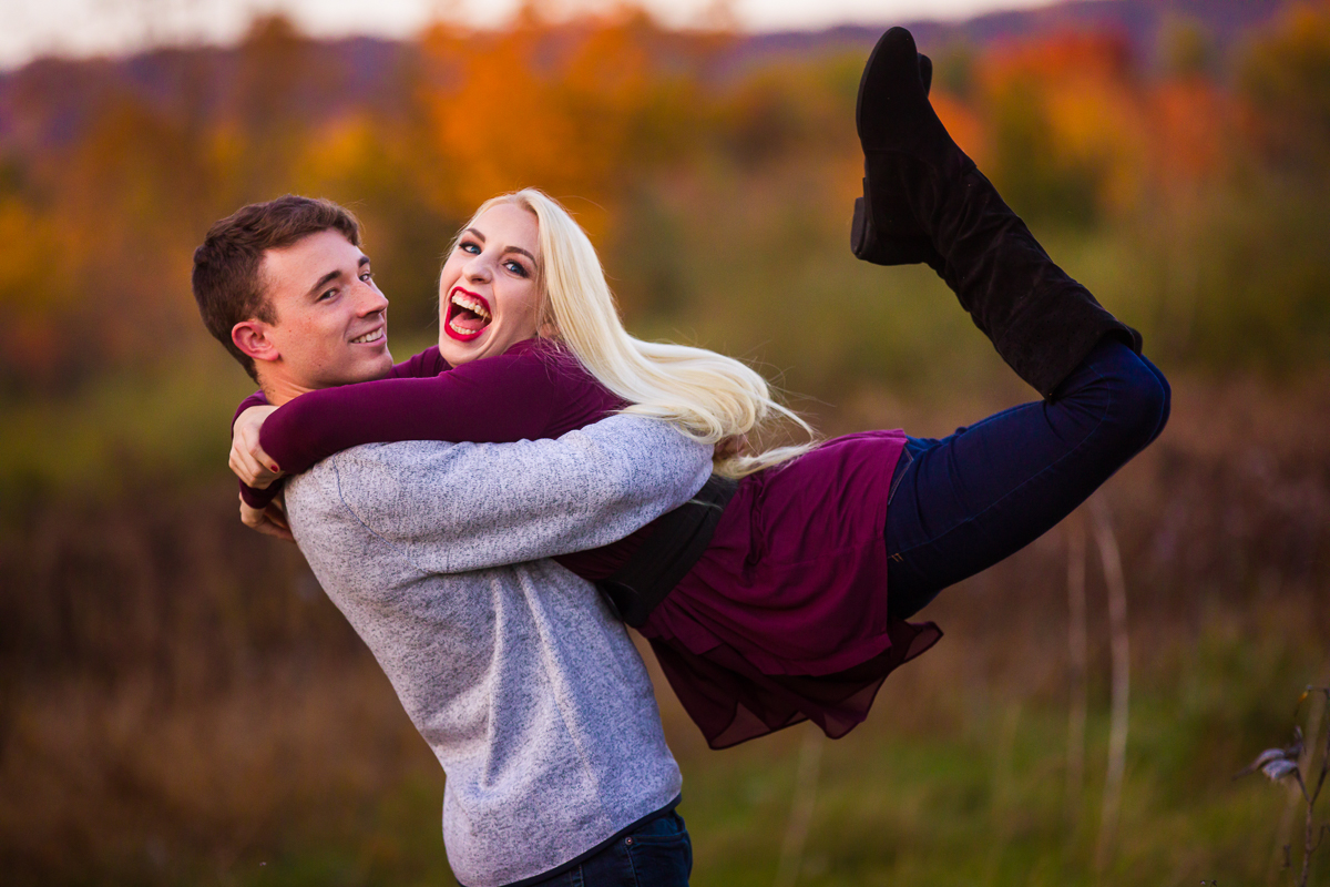 enthusiatic bride is swung by fiancé in vibrant fall wedding engagement photography session in pennsylvania near LVC