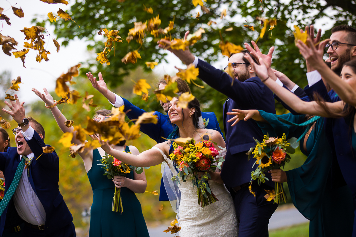 wedding party throws leaves during a vibrant fall wedding at the gettysburg lodges autumn