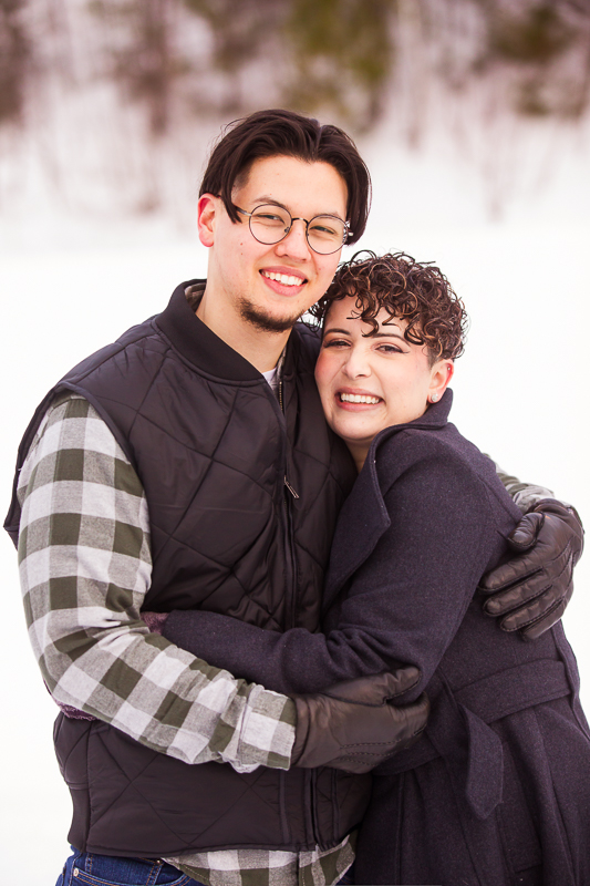 engaged couple in snowy blue mountain resort