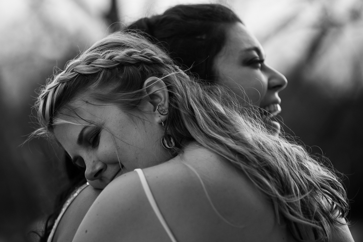 black and white two brides hugging during portraits