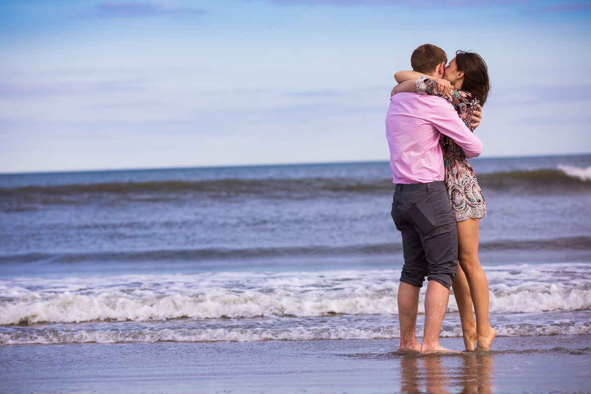 man-woman-hugging-laughing-on-beach-barefoot