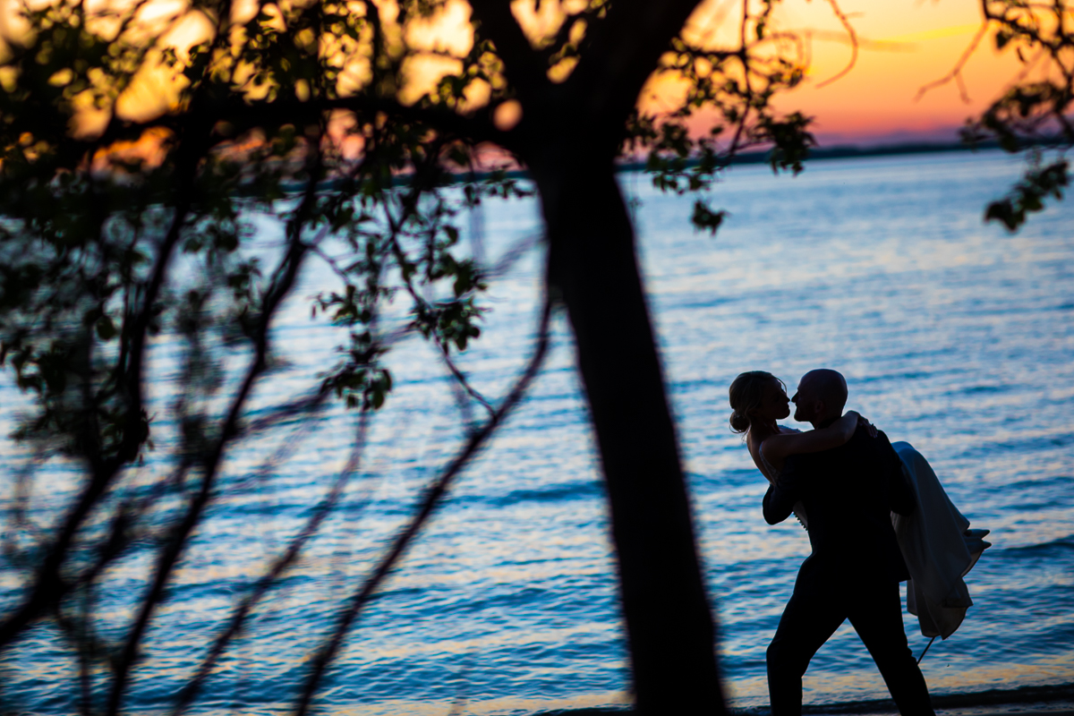 Stevensville Maryland wedding photographer creative Chesapeake bay at sunset bride and groom are silhouetted 