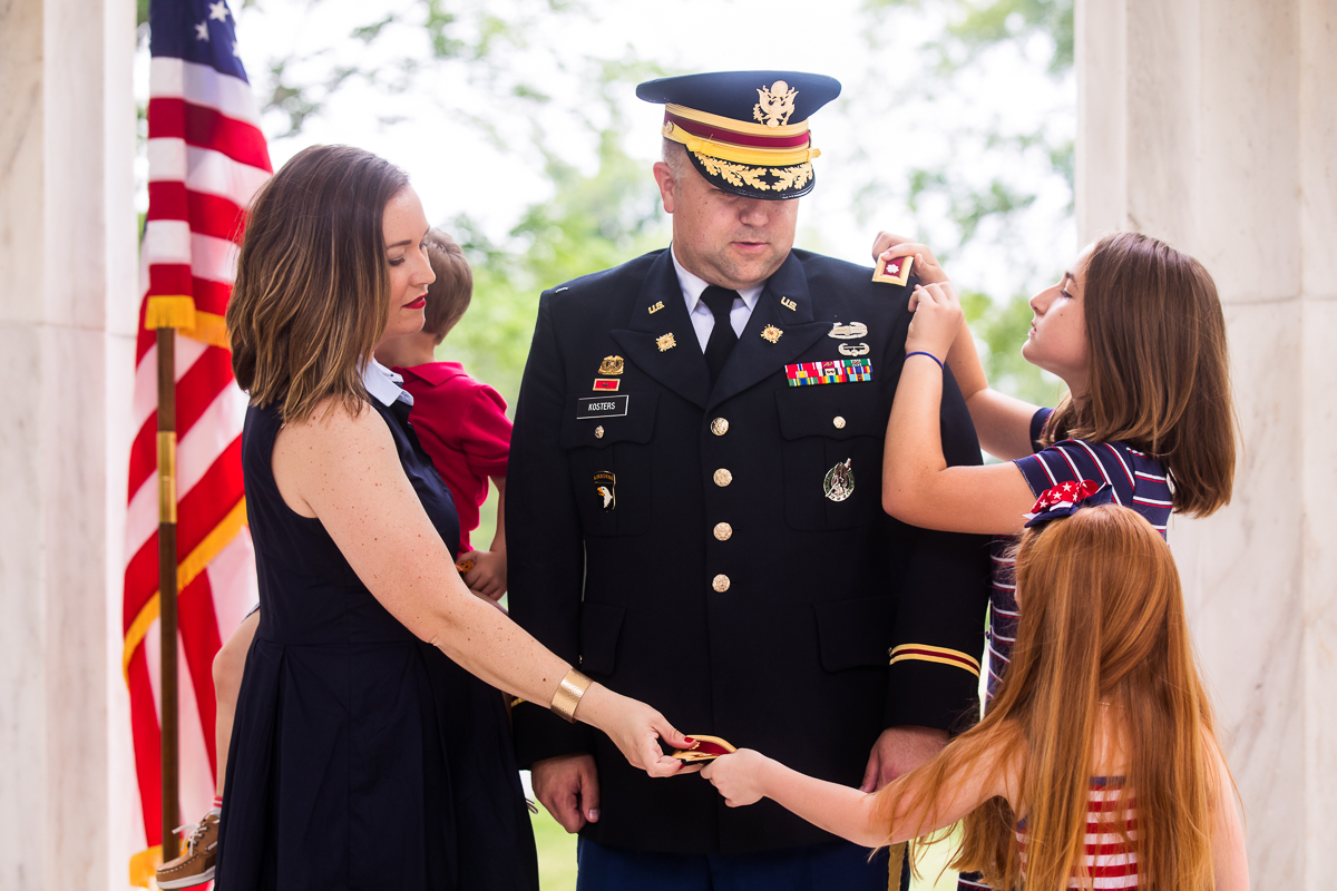 family members pinning badges on army colonel who was newly promoted best DC family photographer military promotion ceremony