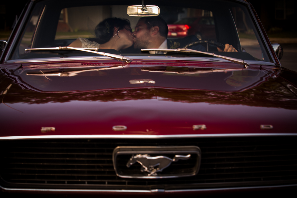 bride and groom kissing inside Ford Mustang
