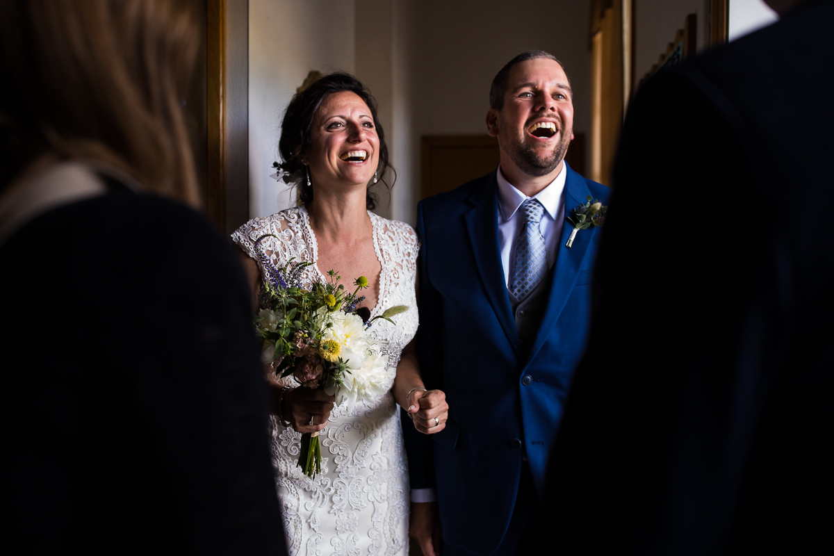 bride and groom smiling while talking to guests after ceremony authentic candid wedding photographer 