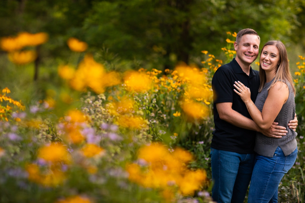 omni Bedford Springs resort photographer couple standing smiling looking at camera in field of purple and orange wildflowers