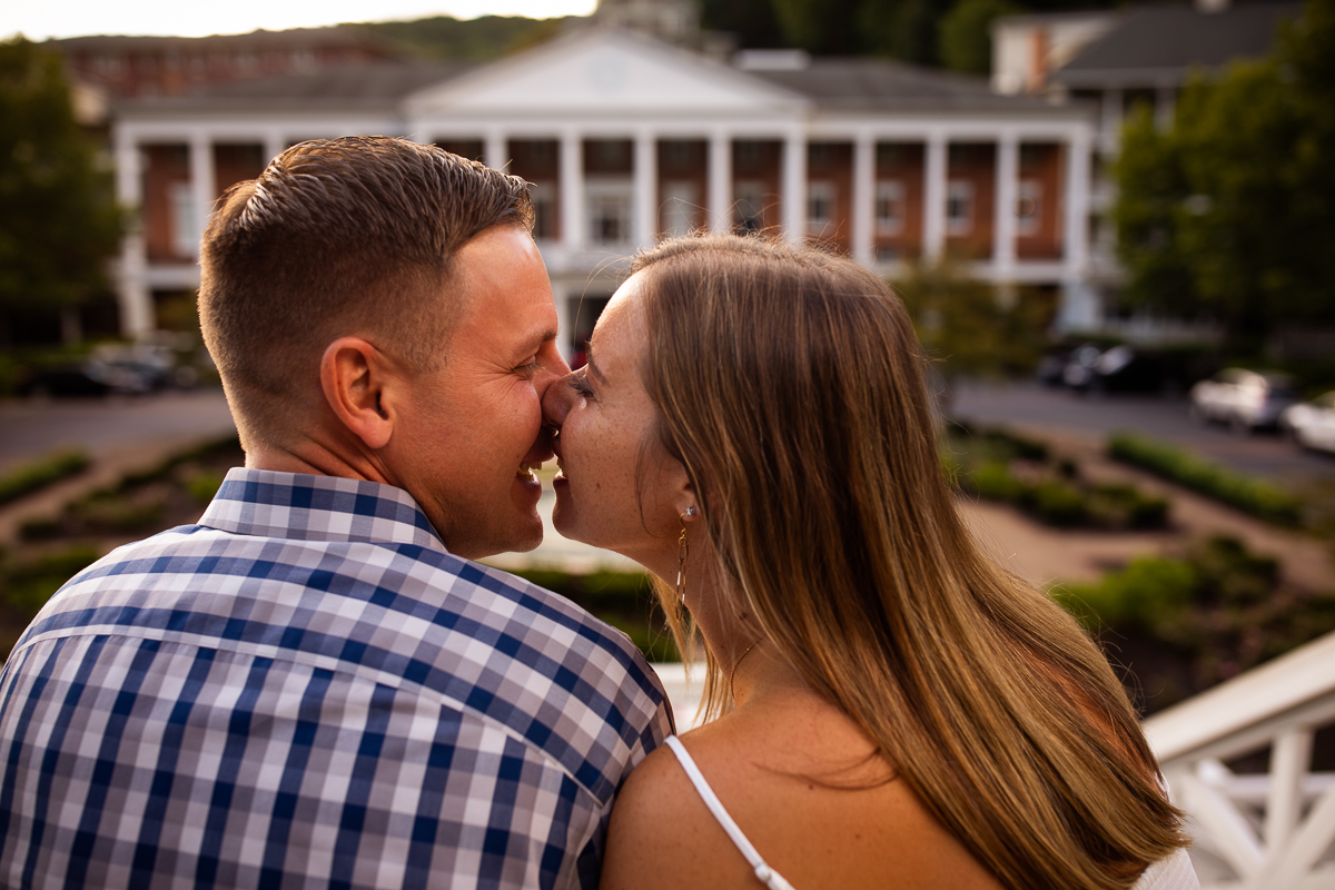 creative unique authentic omni Bedford Springs engagement photographer couple smiling at each other in front of omni resort