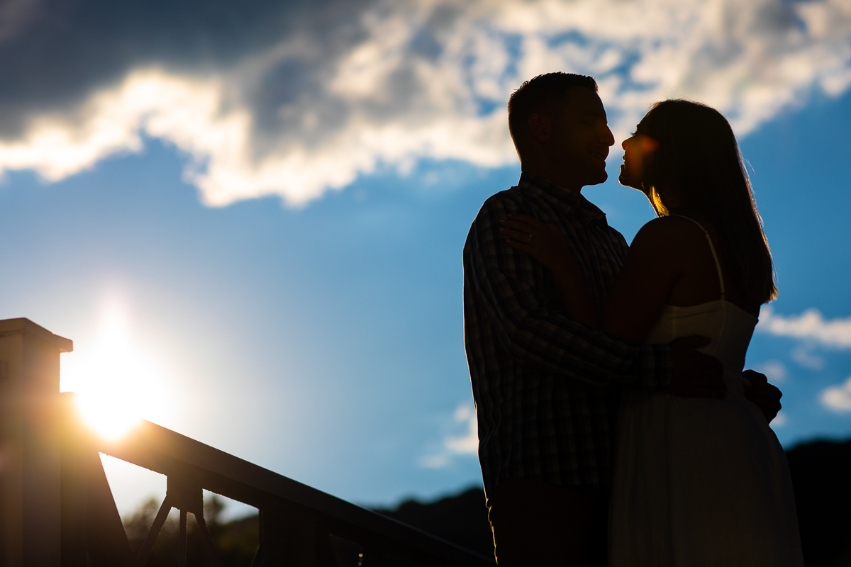 best award winning creative central pa wedding engagement photographer couple silhouetted against vibrant blue sky smiling at each other