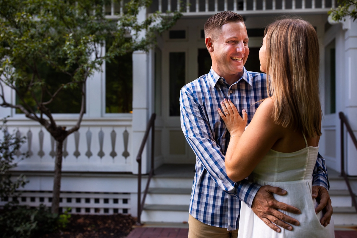 omni Bedford Springs resort engagement photographer couple holding each other smiling in front of steps of omni resort