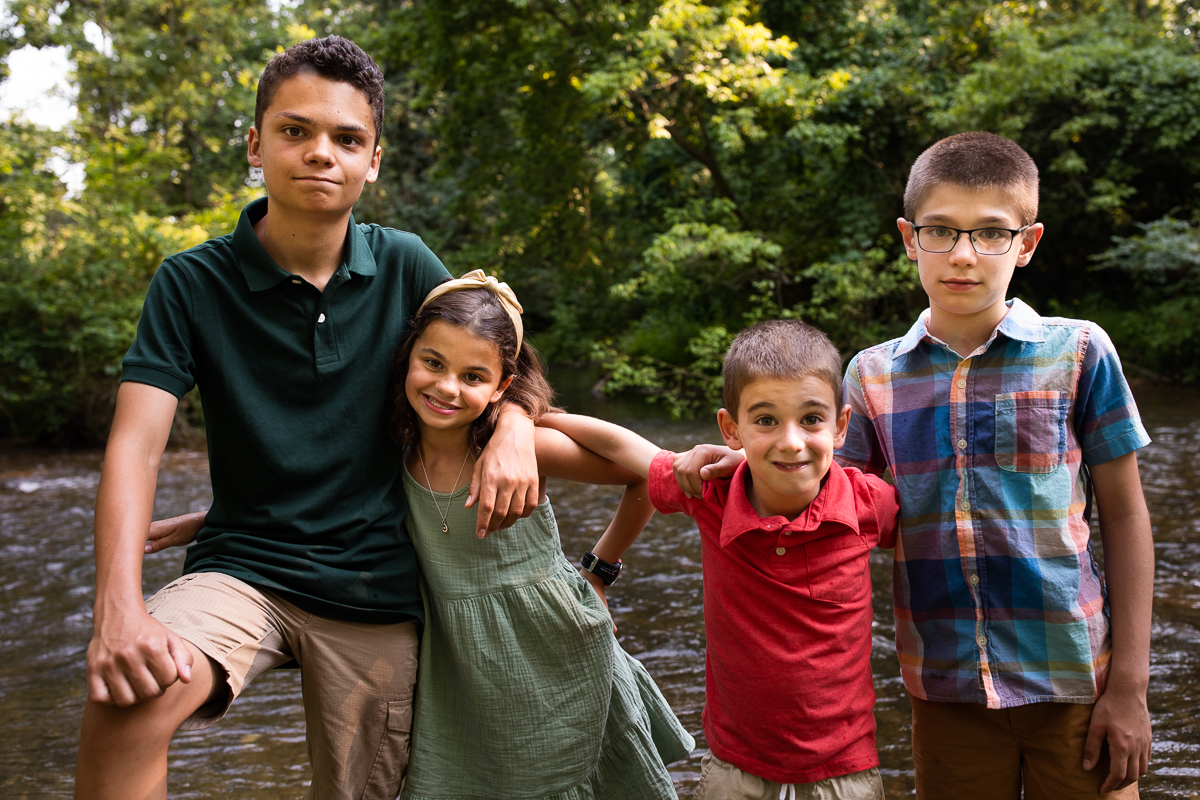 authentic vibrant award winning best photographer central pa lifestyle kids standing in front of creek at yellow breeches smiling