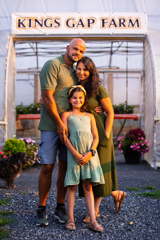 kings gap farm Carlisle pa family portrait photographer family standing in front of entrance smiling wearing green