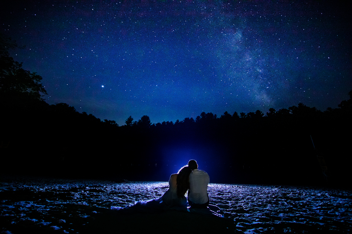 Milky Way after session photographer Appalachian trail couple sits on ground surrounded by blue sky and stars astral photography creative unique 