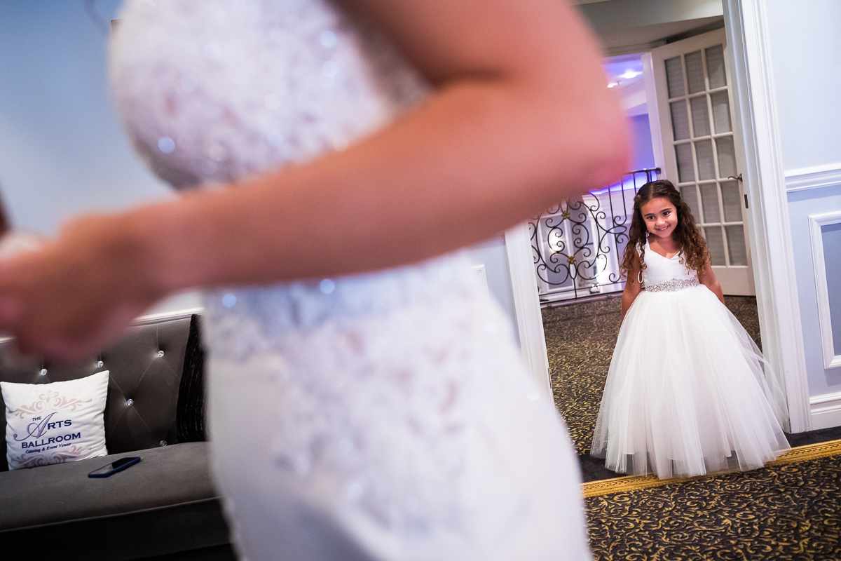 flower girl walking in to see bride for first time on wedding day at arts ballroom Philadelphia wedding