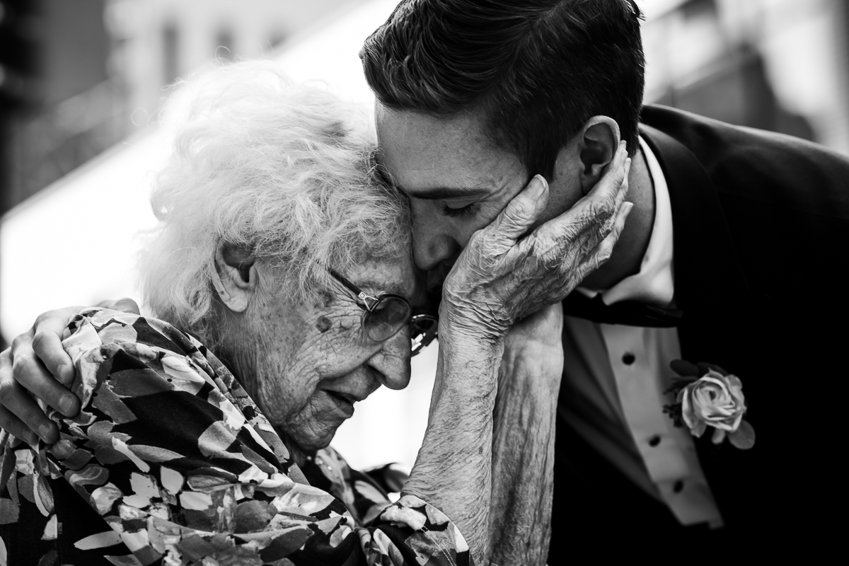 artistic creative emotional black and white photo of grandma holding grooms face during wedding reception best award winning emotional wedding photographer central pa