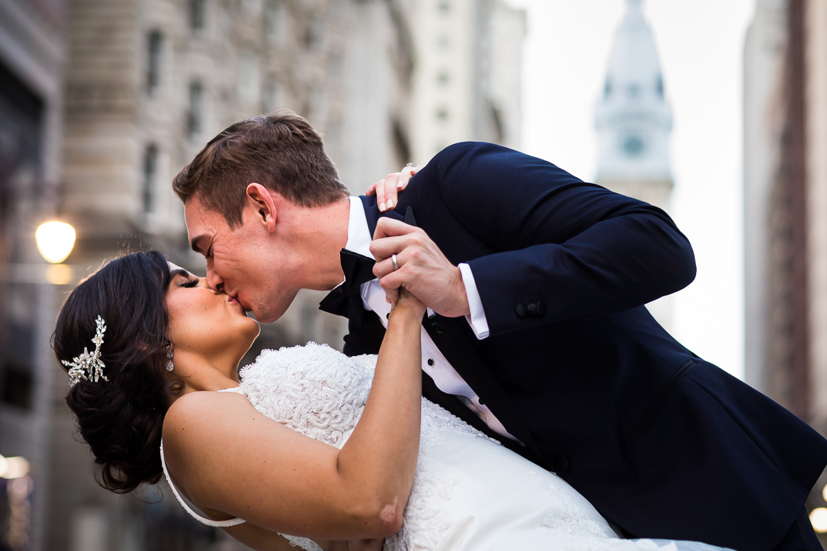 Philadelphia city hall wedding photographer bride and groom kiss with city hall in background downtown Philadelphia wedding photo idea