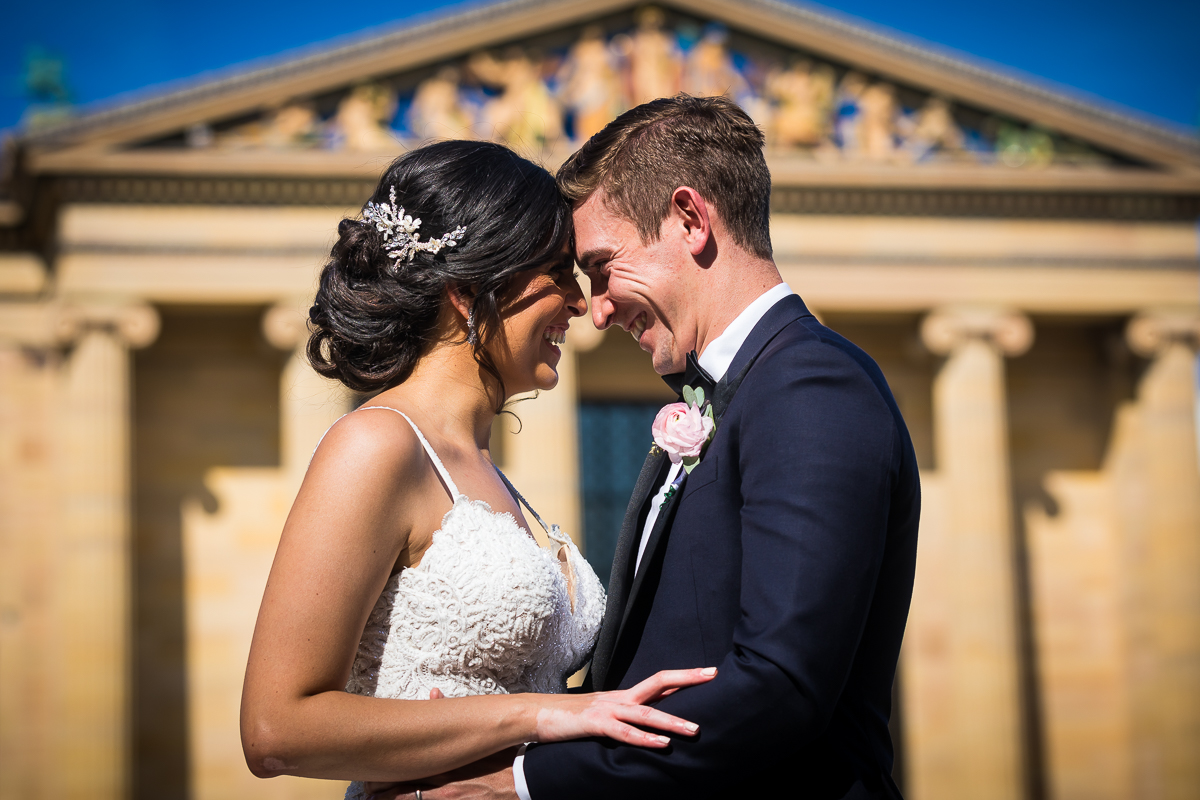 Philadelphia museum of art wedding photographer bride and groom smile at each other standing in front of museum
