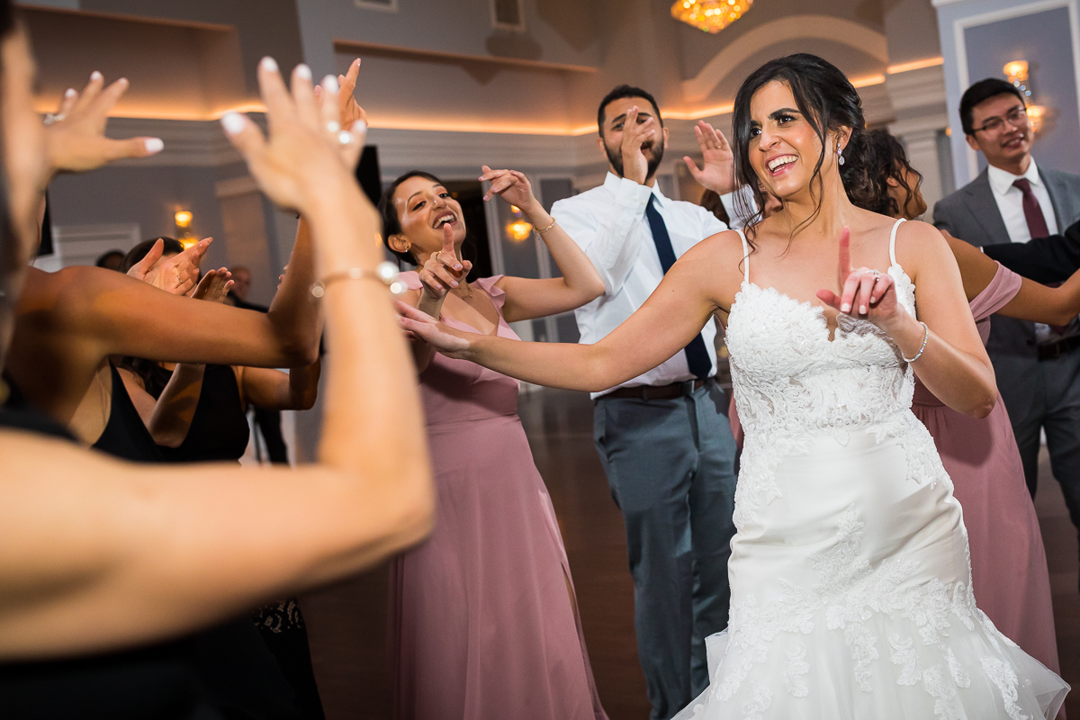 bride and guests dancing together during wedding reception
