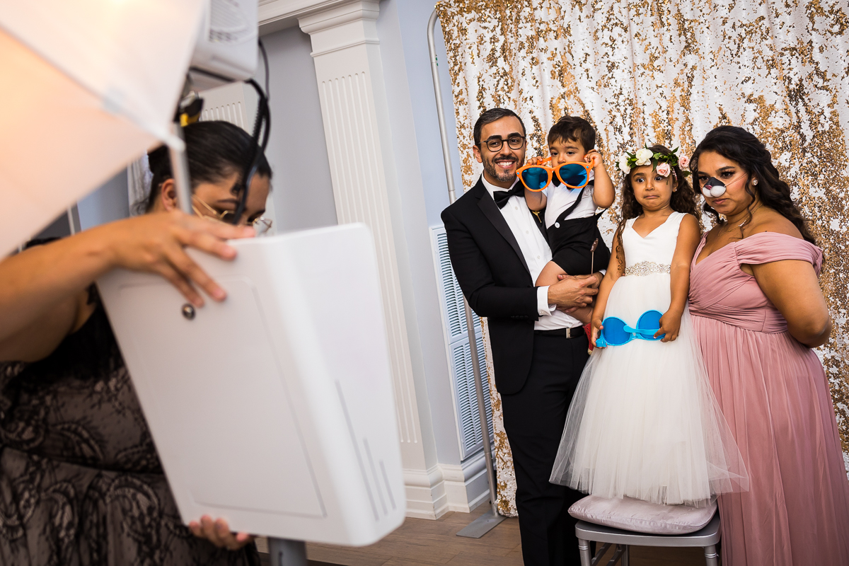 guest standing in front of photo booth during wedding reception flower girl making funny face