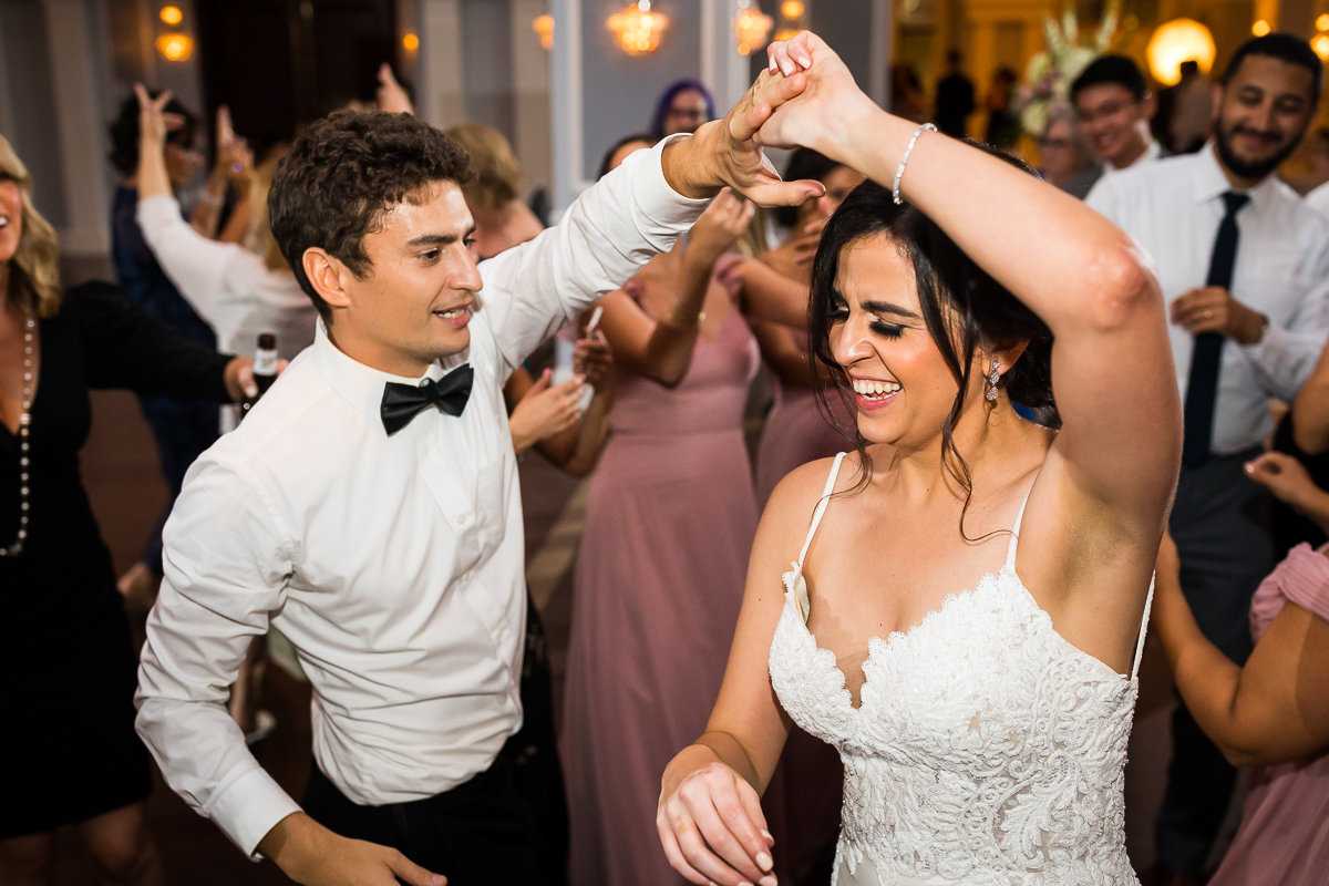 bride being spun around by wedding guest during reception dancing time authentic candid photo pa wedding photographer