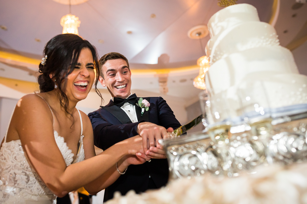 authentic candid pa wedding photographer bride and groom laughing while cutting cake together