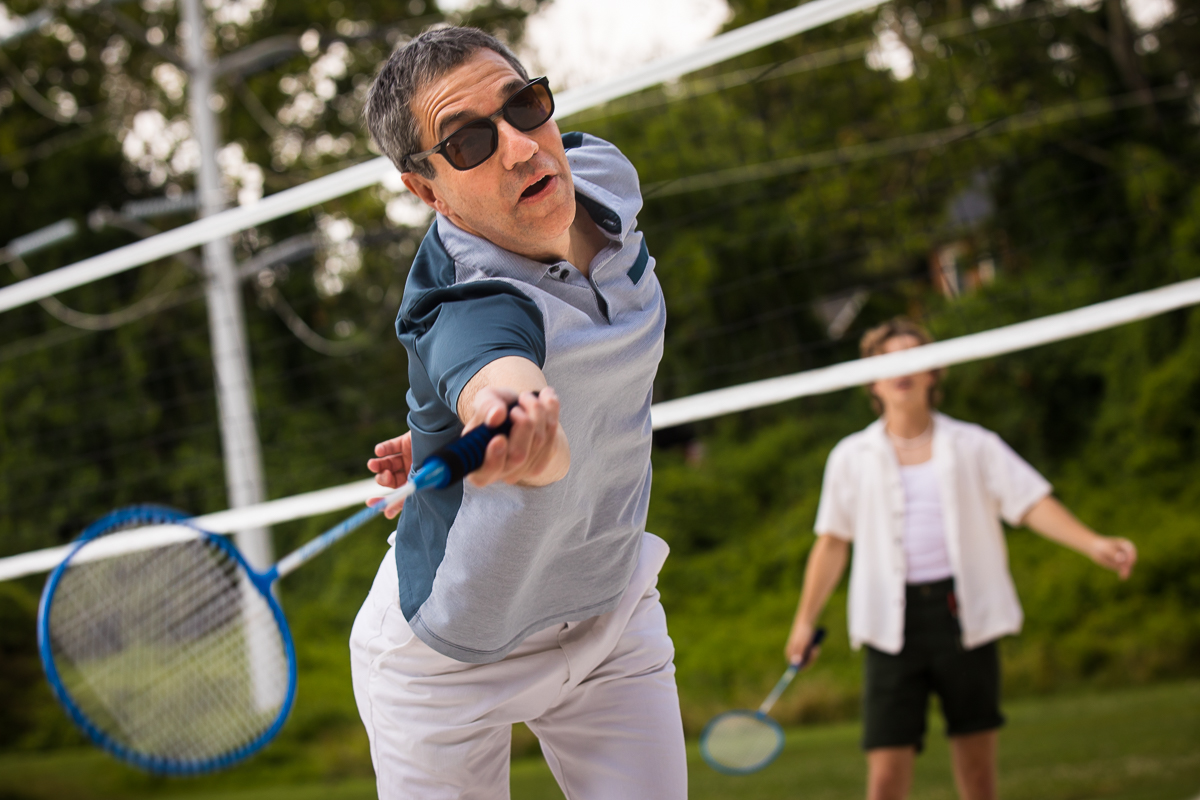 creative unique fun party photographer DC VA man swings badminton racket 
