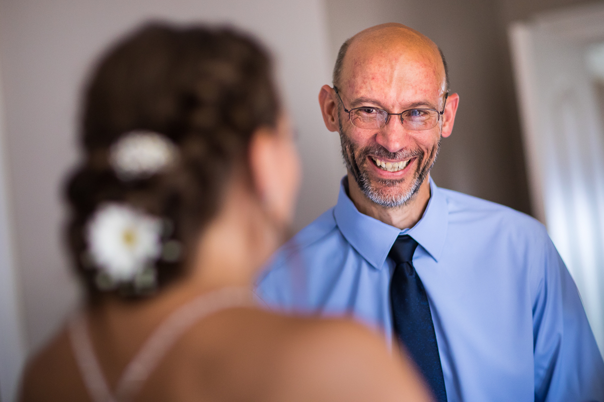 emotional candid wedding photographer central pa dad smiles at bride daughter during first look