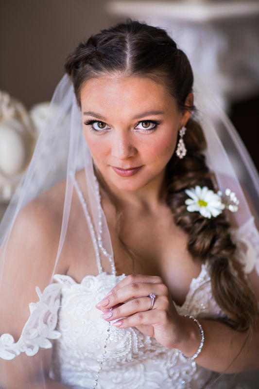 central pa award winning photographer bride holding veil looking at camera during bridal portraits