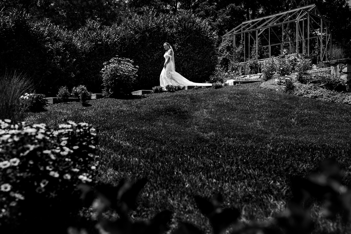 historic acres of Hershey first look black and white photo of bride walking down steps to meet groom