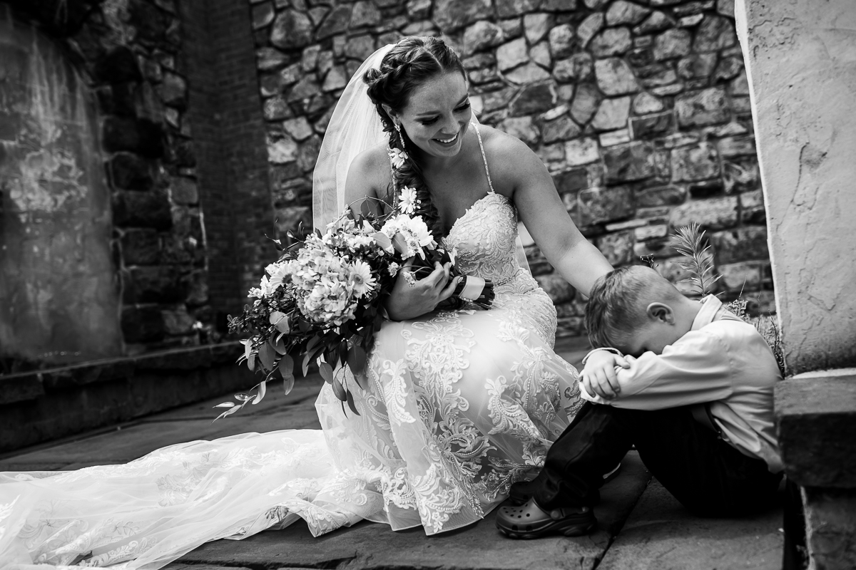 authentic candid wedding photographer central pa black and white photo bride comforting brother while he is upset before wedding ceremony