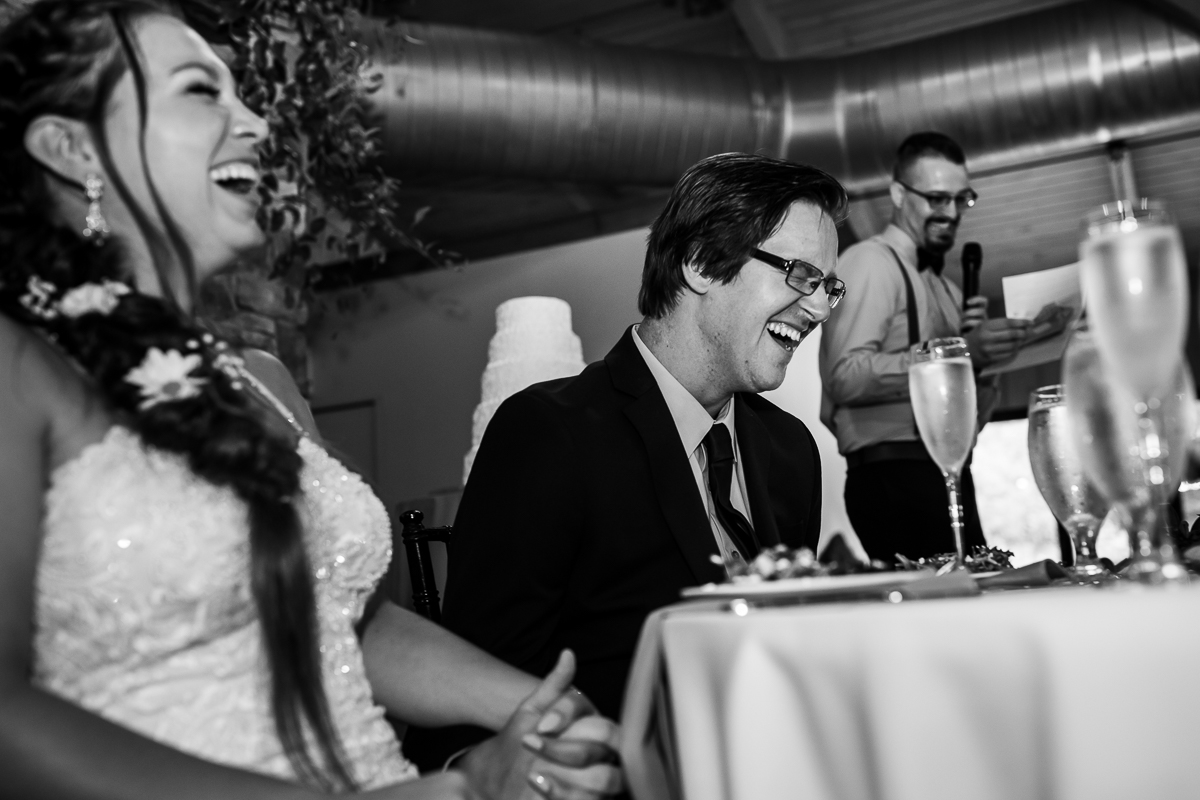 authentic candid emotional central pa wedding photographer bride and groom laugh while best man reads speech during reception