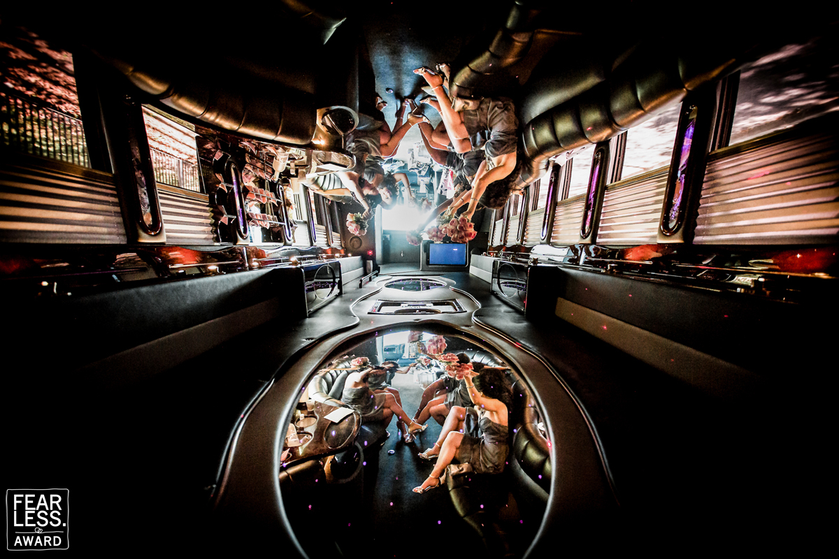 Unique perspective of the wedding party in the party bus on the way to the reception. The wedding party is captured in the mirrors on the roof for this Fearless Photographer Award winning photo by Rhinehart Photography and one of the best wedding photographers in pa Pennsylvania 