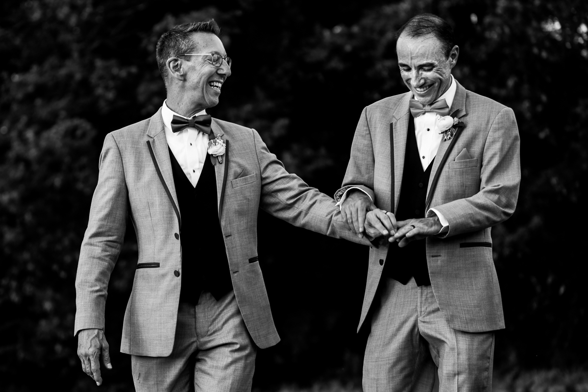 black and white photo of two grooms admiring their wedding rings after national arboretum wedding ceremony joyful happy authentic 