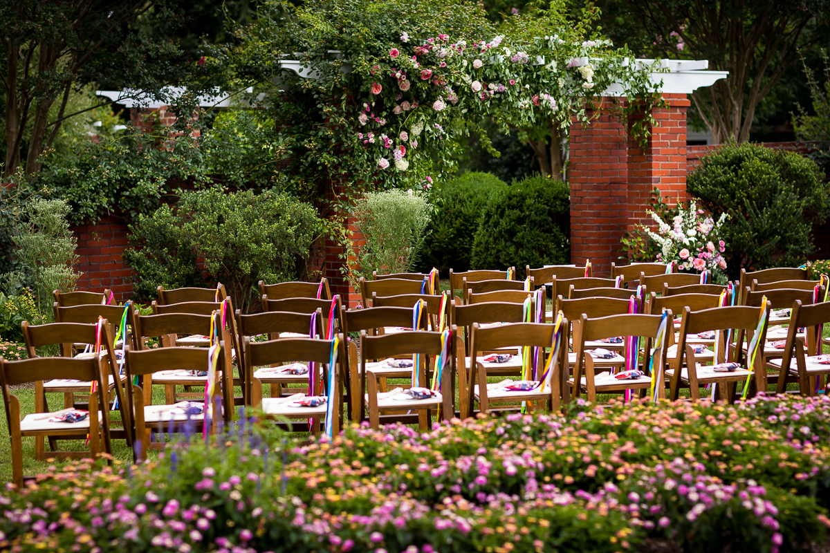 colorful vibrant best award winning wedding photographer ceremony set up at river farm with colorful streamers and pink and white flowers