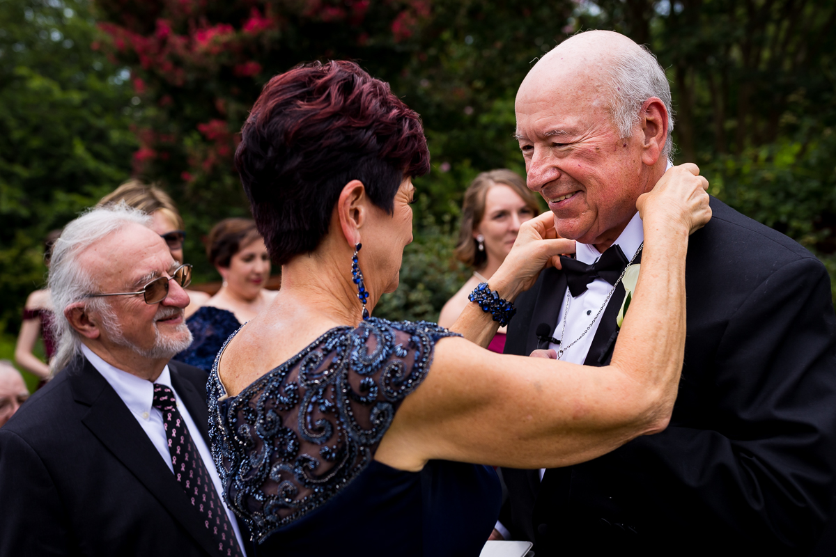 emotional joyful wedding photographer dc mother of bride puts necklace on father before ceremony