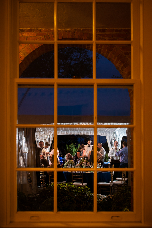 river farm Virginia wedding photographer artistic wedding photographer guests reflected into window outside during reception