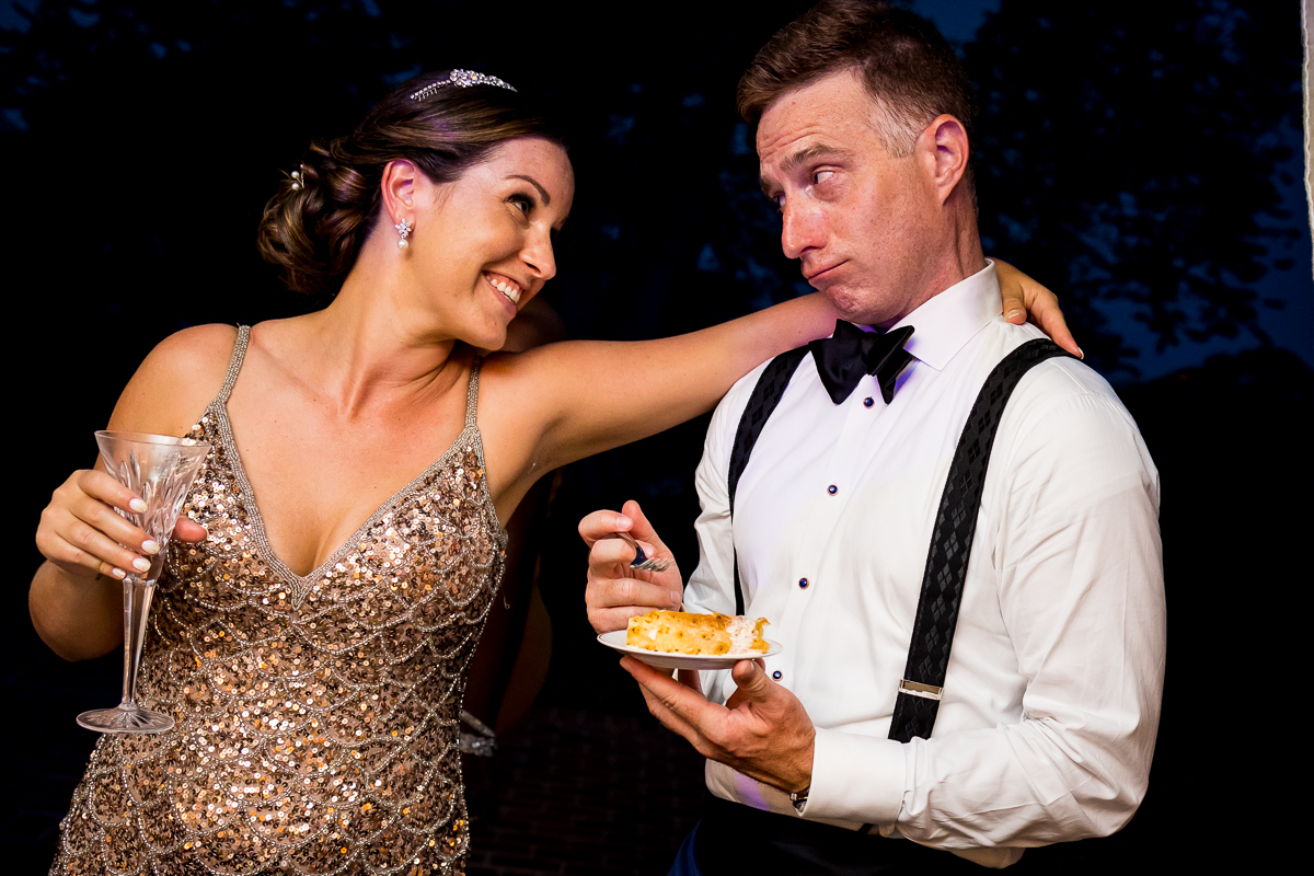 best river farm wedding photographer bride and groom smile at each other while sharing dessert at reception