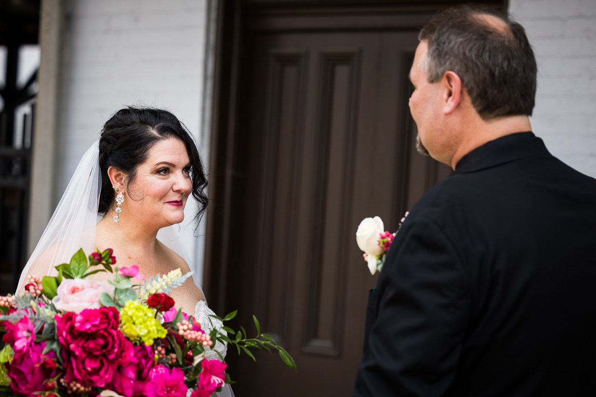 bride and groom smile at each other during first look at gettysburg train station