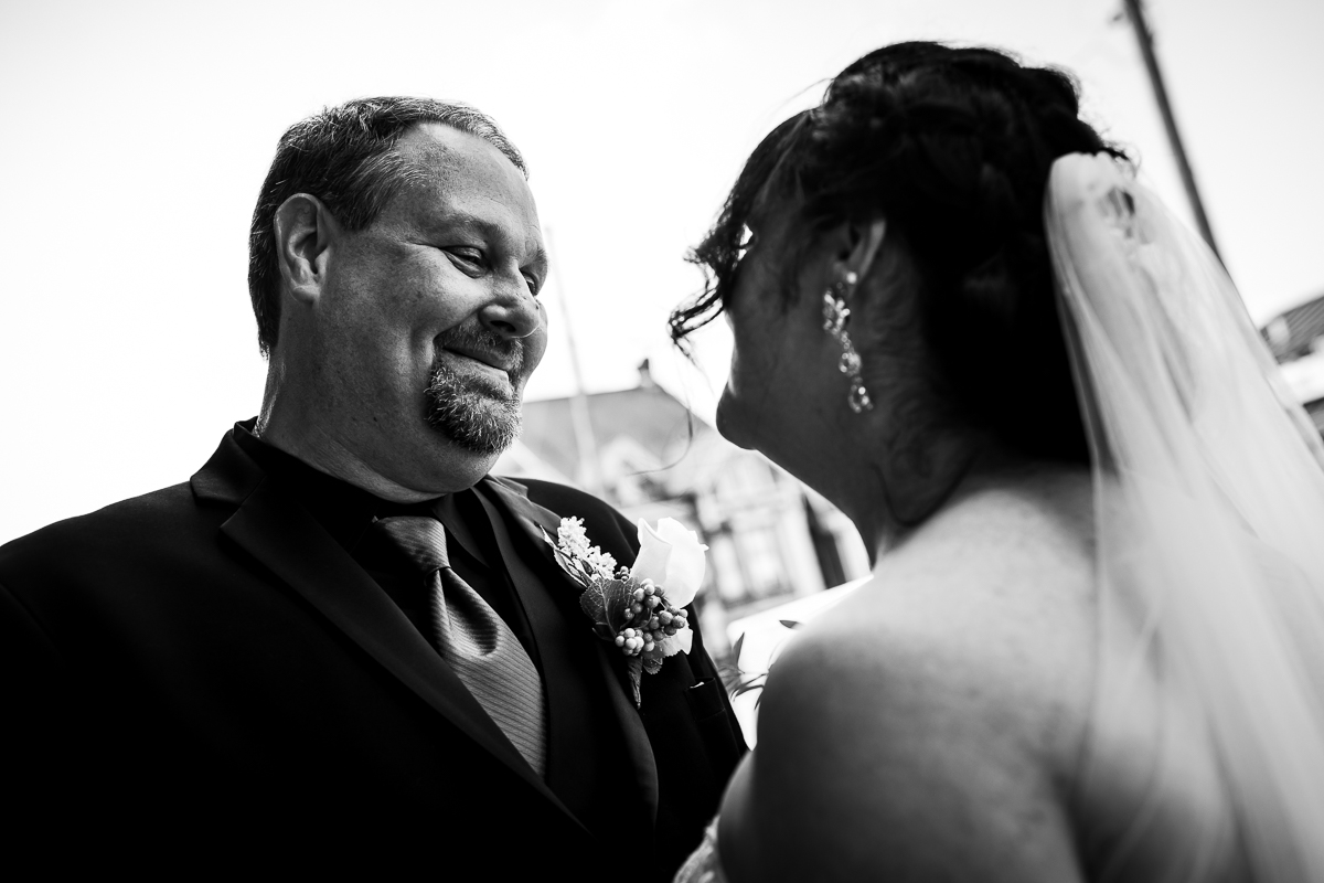 creative authentic gettysburg wedding photographer black and white photo of bride and groom smile at each other outside gettysburg hotel
