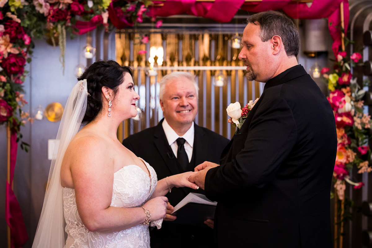best gettysburg hotel wedding ceremony officiant smiles as groom puts ring on bride's hand