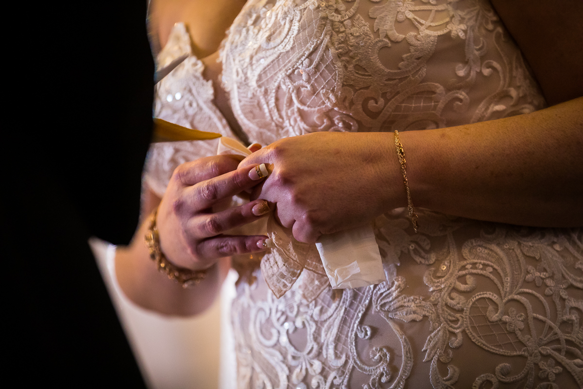 close up of bride's hands holding tissue listening to groom's vows during gettysburg hotel wedding ceremony