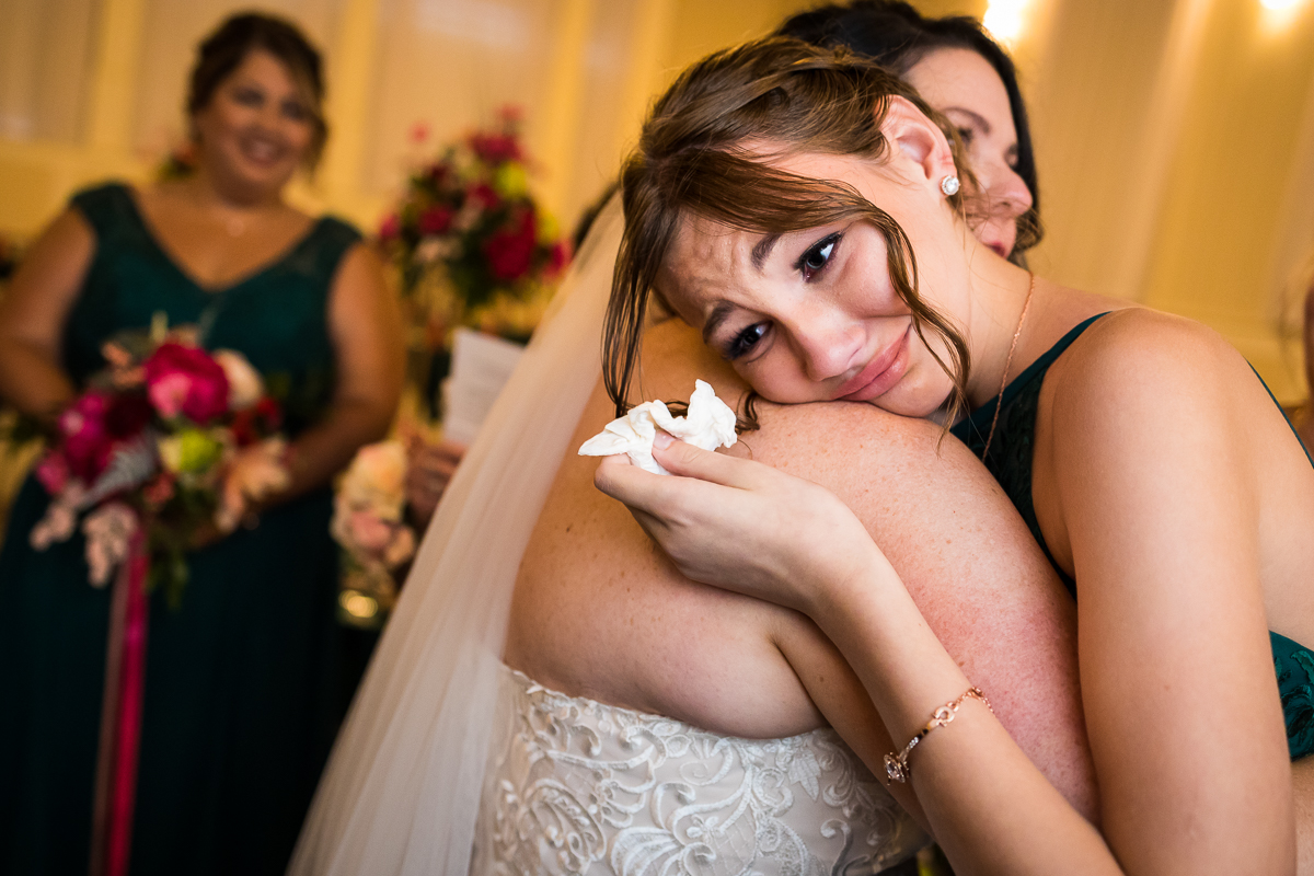 best emotional authentic wedding photographer gettysburg hotel ceremony groom's daughter hugs bride 
