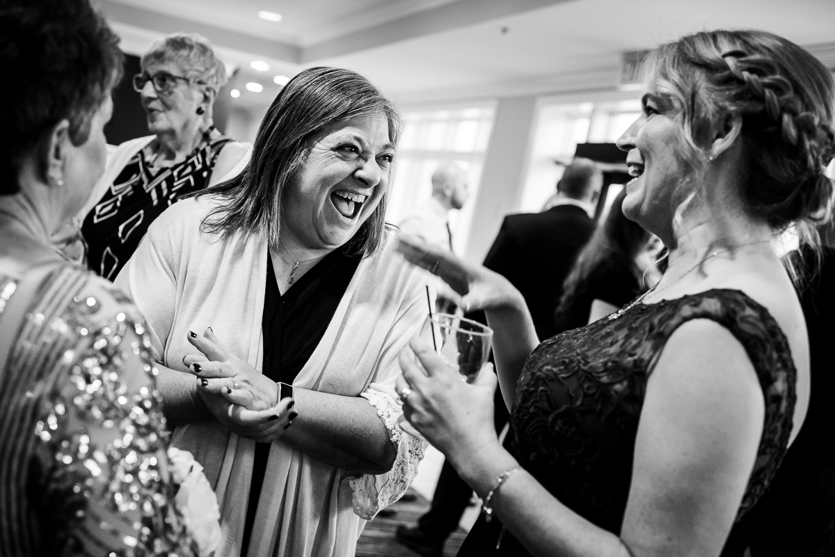 black and white photo of guests smiling and laughing during cocktail hour at gettysburg hotel wedding