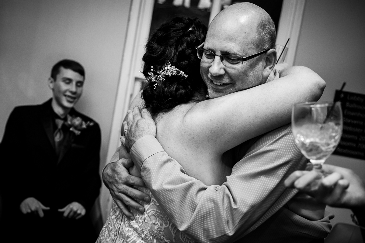 emotional authentic best gettysburg wedding photographer black and white photo bride hugs guest
