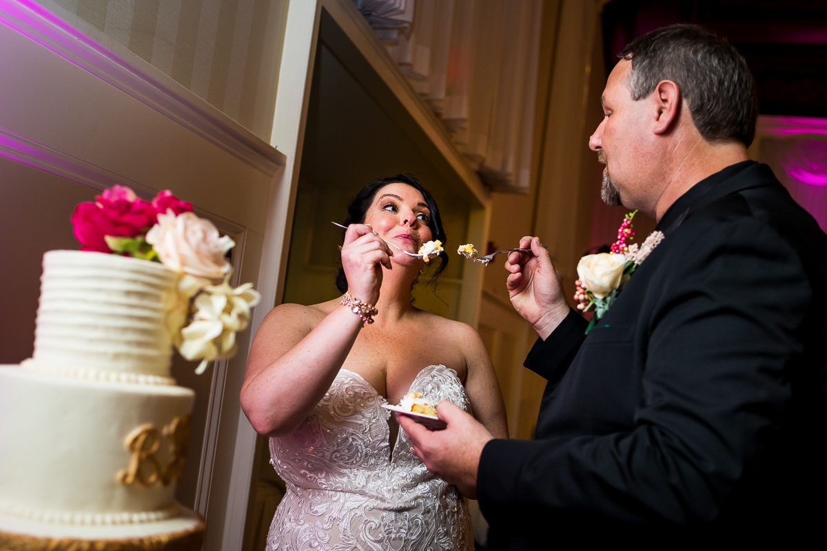 bride and groom feed each other first bite of wedding cake at gettysburg hotel wedding reception