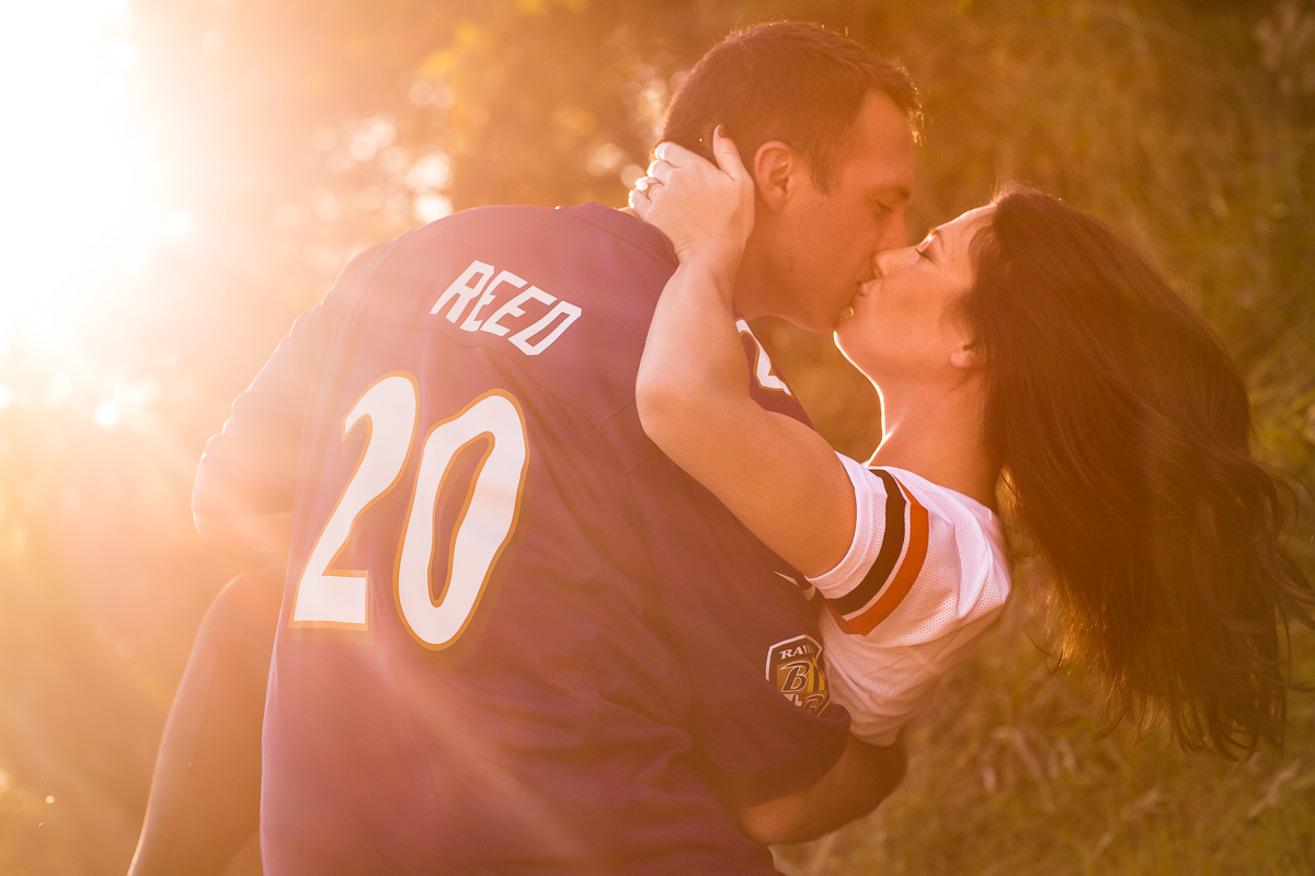 couple kissing during golden hour wearing college sport jersey harpers ferry va engagement