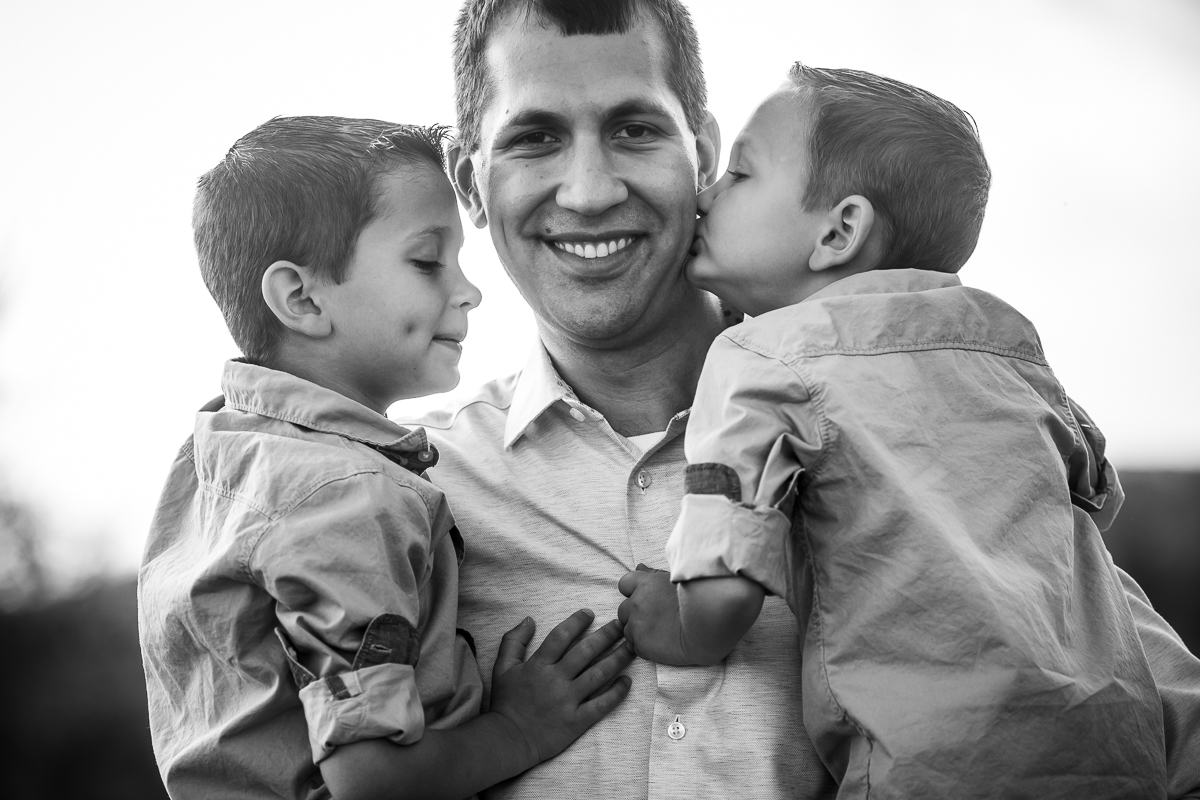 black and white photo of dad holding sons kissing on cheek central pa lifestyle photographer