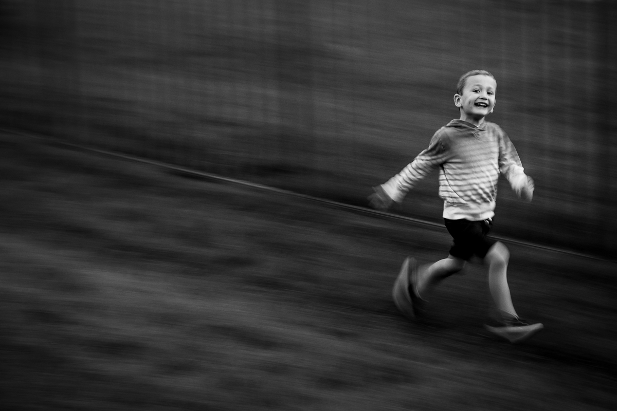 black and white photo of boy running central pa family lifestyle photographer 