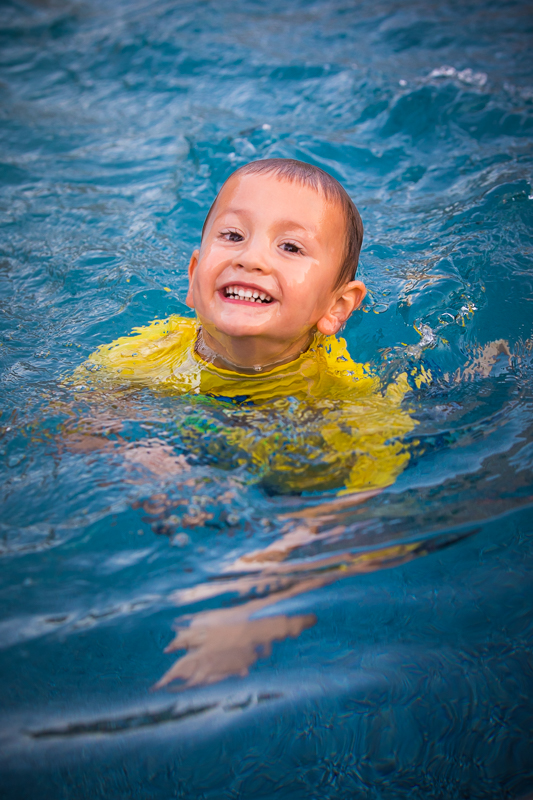 boy swimming in pool smiling happy joyful lifestyle photographer